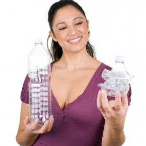 femme avec une bouteille en plastique recyclé